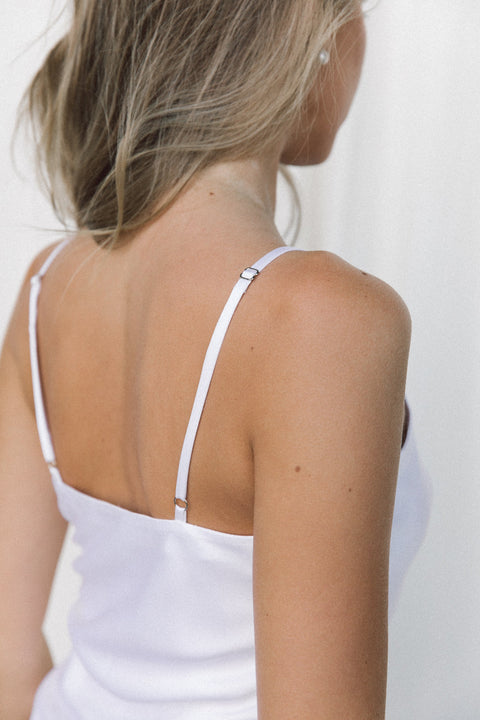 Close-up of woman wearing a white silk camisole with adjustable straps