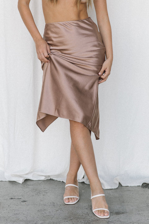 Model wearing taupe silk slip skirt posing in a studio