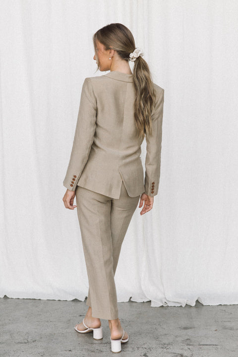 Back view of a model wearing a taupe coloured suit